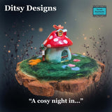 Small fairy house with a red polka-dot mushroom roof and a butterfly on top on a wooden stump, surrounded by plants and a felted garden on a slice of log with 'Ditsy Designs' branding at Parade-Handmade