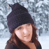 Woman wearing a dark knit beanie in a snowy landscape - Parade Handmade