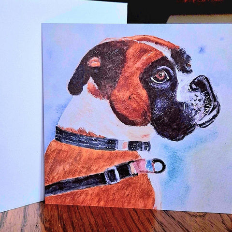 Artistic watercolour illustration on a card of a boxer dog with a collar on a wooden table by Nuala Brett-King - Parade Handmade
